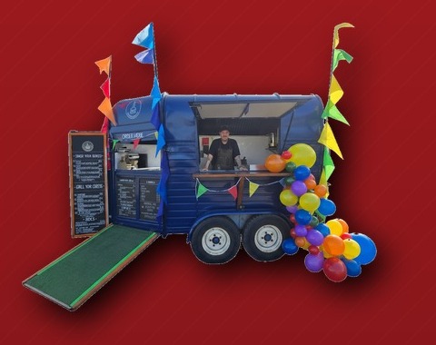 The Iron Griddle Co — blue converted horsebox food trailer with bunting and balloons